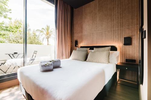 a bedroom with a large white bed and a balcony at Hotel Arena Select in Valencia