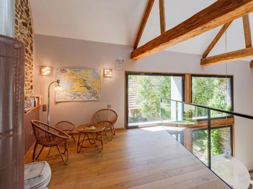 - un salon avec une table, des chaises et une grande fenêtre dans l'établissement Holiday Home La Gicquelière by Interhome, à Jullouville