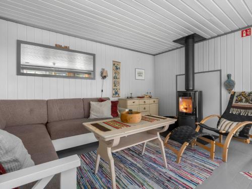 a living room with a couch and a wood stove at Holiday Home Berthabu by Interhome in Øyuvstad