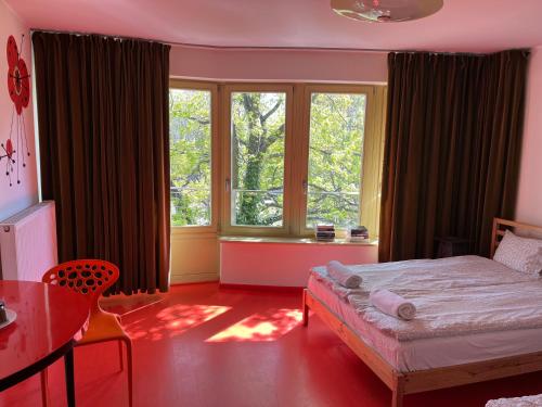 Un dormitorio con una cama y una mesa y una ventana. en Lalala, en Sopot