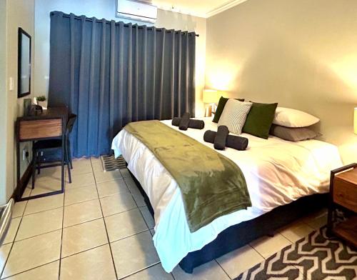 a bedroom with a large bed and a desk at Fish Eagle Manor in Warmbaths
