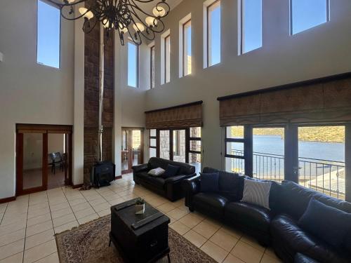 a large living room with a couch and a chandelier at Fish Eagle Manor in Warmbaths
