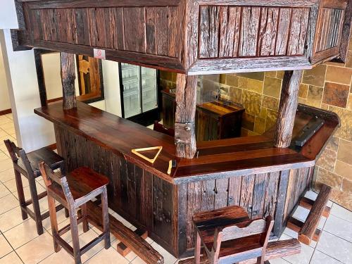 a wooden counter with two chairs and a table at Fish Eagle Manor in Warmbaths