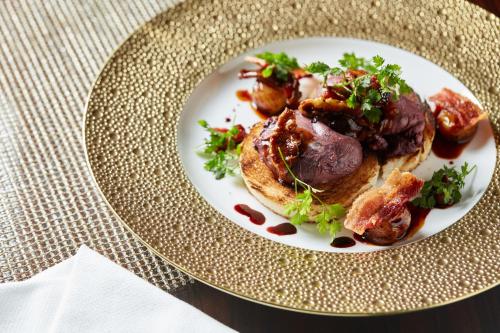 a plate of food with meat and vegetables on a table at Four Seasons Hotel New York in New York