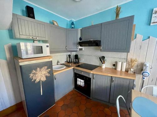 a kitchen with a refrigerator and a sink and a microwave at Côte & Mer in Fécamp