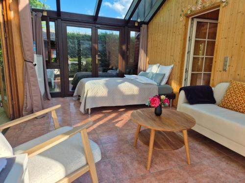 ein Zimmer mit einem Bett, einer Couch und einem Tisch in der Unterkunft Cosy Cottage in Braunfels