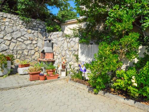 a garden with potted plants and a stone wall at Holiday Home Ivan by Interhome in Šilo