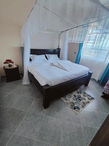a bedroom with a large bed with a canopy at A Oasis Taveta in Taveta
