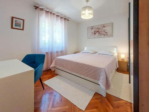 sypialnia z łóżkiem i niebieskim krzesłem w obiekcie Apartment Kraljic by Interhome w mieście Kornić