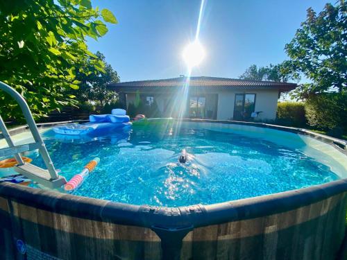 a person swimming in a pool with the sun shining at Sea You Guest House in Ezerets