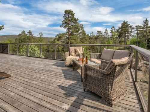 a deck with wicker chairs and a table on a balcony at Chalet Knøttebu by Interhome in Øyuvstad