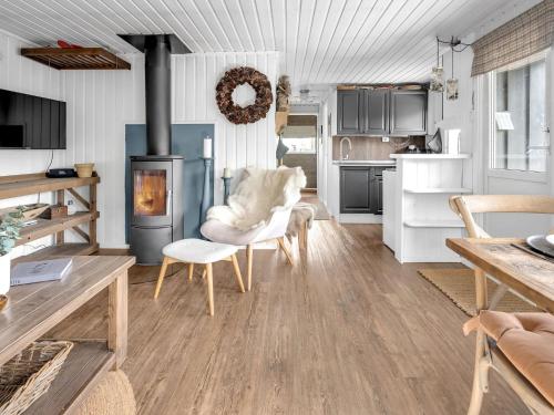a kitchen with a living room with a fireplace at Chalet Knøttebu by Interhome in Øyuvstad