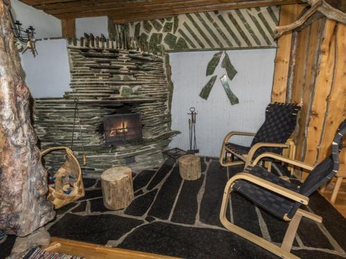 ein Wohnzimmer mit zwei Stühlen und einem Kamin in der Unterkunft Holiday Home Örtsylä a by Interhome in Salla