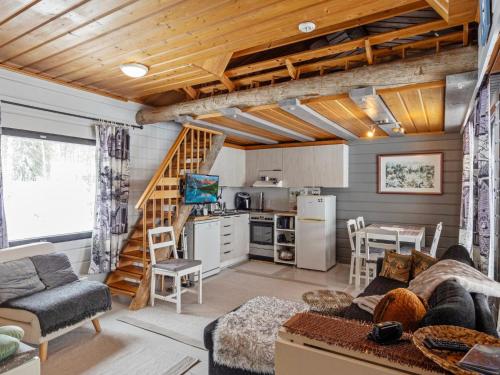 ein Wohnzimmer mit Couch und Küche in der Unterkunft Holiday Home Mustalampi 5 satakieli by Interhome in Ruka