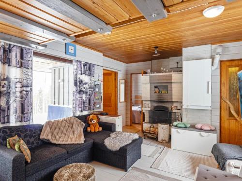 ein Wohnzimmer mit Couch und Kamin in der Unterkunft Holiday Home Mustalampi 5 satakieli by Interhome in Ruka