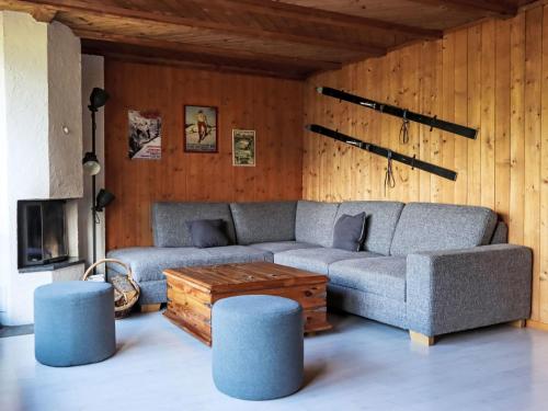 a living room with a couch and some blue stools at Chalet Egg-Isch by Interhome in Grindelwald