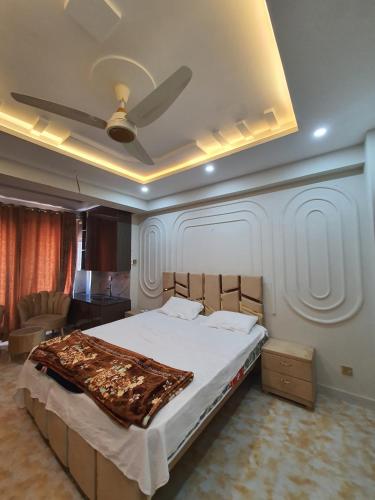a bedroom with a large bed with a ceiling at Pova Hotel Suits and Apartments in Rawalpindi