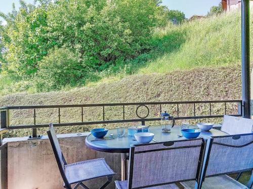 une table avec des bols dessus assise sur un balcon dans l'établissement Apartment Clos de la fontaine 2 by Interhome, à Saint-Gervais-les-Bains