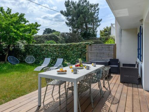 une table blanche et des chaises sur une terrasse dans l'établissement Holiday Home Les Marines by Interhome, à Carnac-Plage