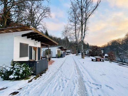 a snow covered road in front of a house at Tiny Ferienhaus 4 am Rimbach in Steinau an der Strasse in Steinau an der Straße