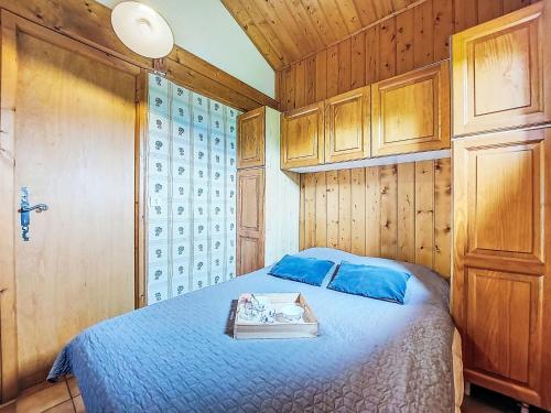 - une chambre dotée d'un lit avec des draps bleus et des murs en bois dans l'établissement Holiday Home Les Farfadets by Interhome, à Saint-Gervais-les-Bains