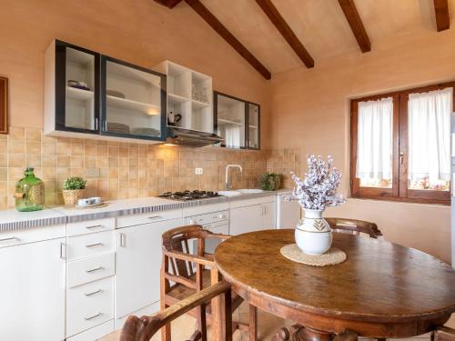 a kitchen with a wooden table and a vase of flowers at Holiday Home Il Nido by Interhome in Li Valcaggi