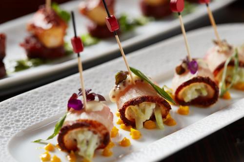 a plate of appetizers on skewers on a table at Four Seasons Hotel New York in New York