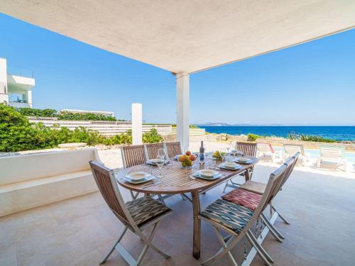 a table and chairs on a patio with the beach at Holiday Home Xoroi by Interhome in Colonia de Sant Pere