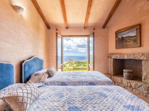 a bedroom with two beds and a large window at Holiday Home Il Nido by Interhome in Li Valcaggi