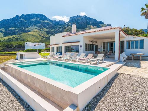 a villa with a swimming pool in front of a house at Holiday Home Xoroi by Interhome in Colonia de Sant Pere