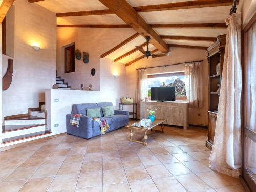 a living room with a blue couch and a tv at Holiday Home Il Nido by Interhome in Li Valcaggi