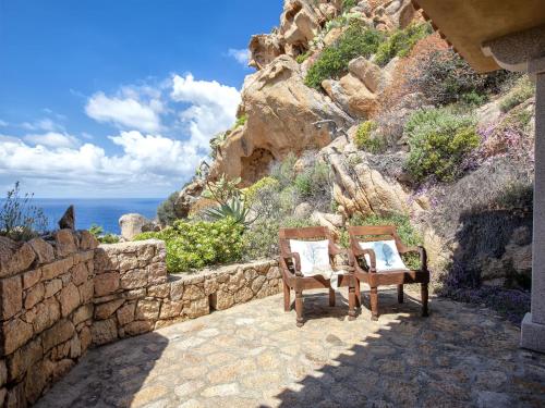 two chairs sitting next to a stone wall at Holiday Home Il Nido by Interhome in Li Valcaggi