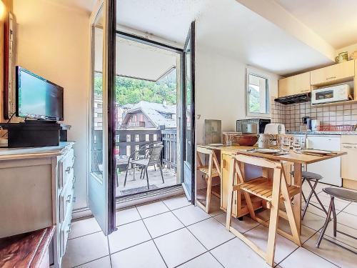 une cuisine avec une table et une vue sur un balcon dans l'établissement Apartment La Comtesse-9 by Interhome, à Saint-Gervais-les-Bains