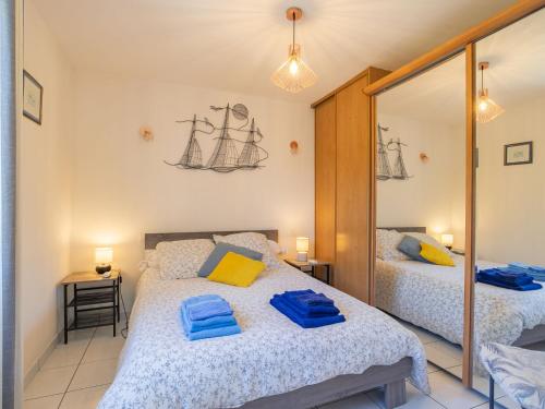 une chambre avec deux lits et un miroir dans l'établissement Studio Les Hortensias by Interhome, à Kerlouan