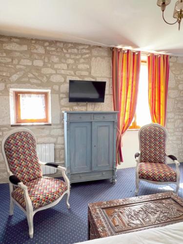 un salon avec deux chaises et une télévision dans l'établissement La Maison d'Alienor - Les Clos - 2ème Etage - Chablis 89, à Chablis