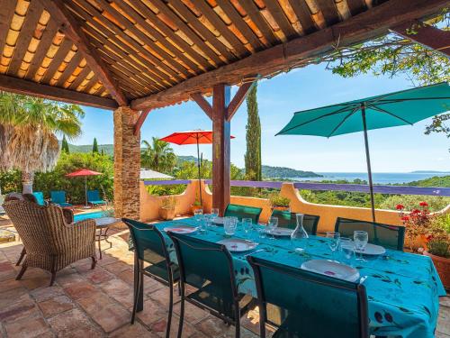 patio ze stołem z krzesłami i parasolami w obiekcie Villa Villa Etoile Filante by Interhome w mieście Le Lavandou