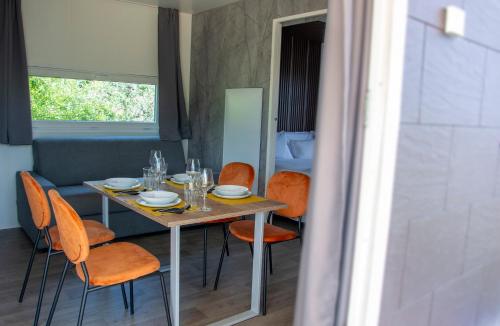 a dining table with orange chairs in a room at Agriturismo Il Giardino Degli Ulivi in Lazise