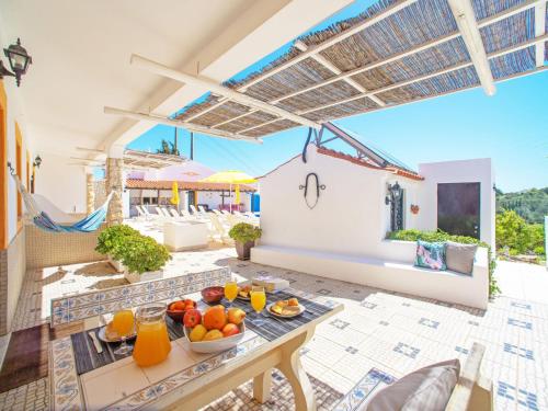 een patio met een tafel met fruit erop bij Holiday Home Eugênia by Interhome in Paderne
