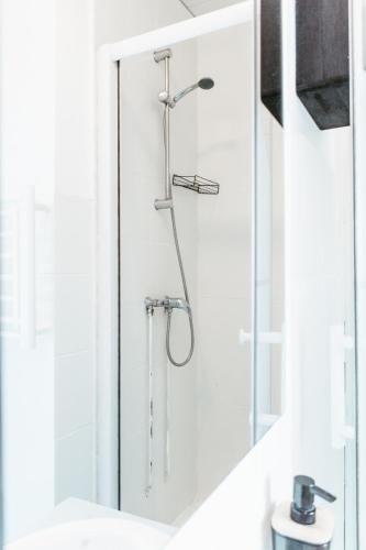 une douche dans une salle de bain avec une porte vitrée dans l'établissement l'Amiral, au Havre