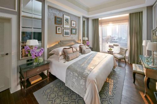 a bedroom with a large bed and a large window at Mandarin Oriental, Bangkok in Bangkok