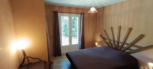 Cette chambre comprend un lit, une fenêtre et une lumière. dans l'établissement Les Lilas des Chênes, à Piolenc