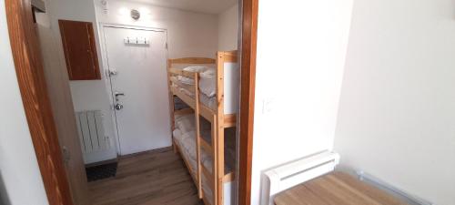 Cette chambre dispose d'un couloir avec des lits superposés et une porte. dans l'établissement Studio 34, Le Génois au Mont st Martin, au Cap d'Agde