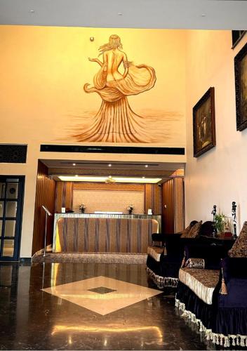 a lobby with a large painting of a woman on the wall at Montecarlo Hotel in Mahabalipuram