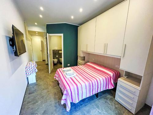 a bedroom with a bed with a striped blanket at Studio Rosso by Interhome in Rapallo