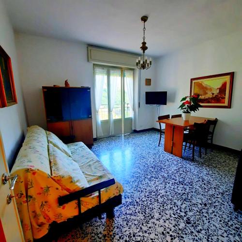 a living room with a bed and a desk and a table at Casa Maioli - Your Mountain Holiday in Casargo