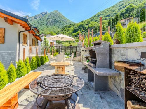un patio con una mesa y una parrilla al aire libre en Apartment Casa La Villa by Interhome, en Verceia