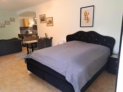 a bedroom with a large bed and a dining room at Schloss Hilbringen Wirtschaftsgebäude in Merzig