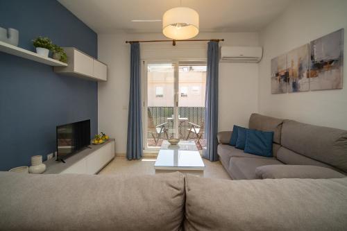 a living room with a couch and a tv at SIBS Sanlúcar Océano-Ideal Familias-Parking y Wifi Gratis in Sanlúcar de Barrameda