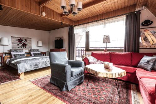 a living room with a red couch and a bed at Golden Villa Panorama Zakopane in Zakopane