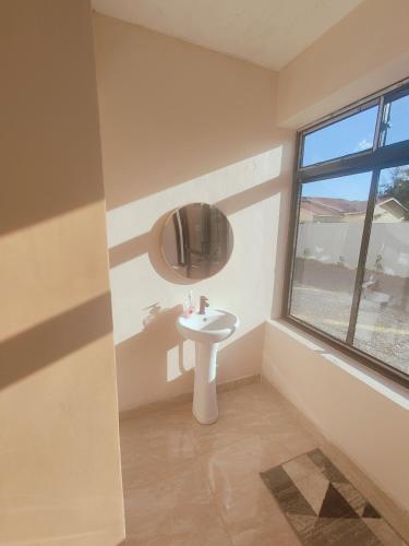 a bathroom with a sink and a window at A Oasis Taveta in Taveta